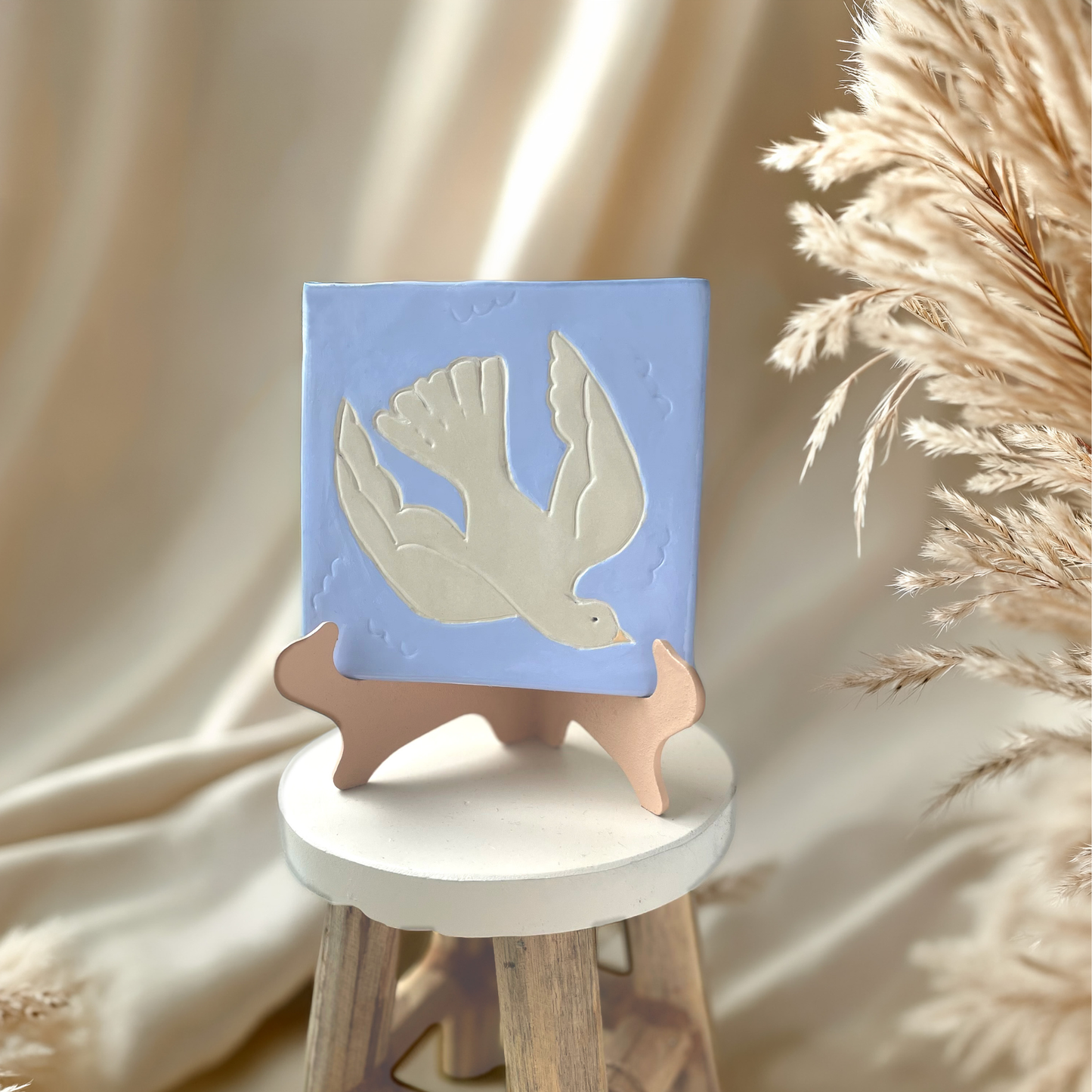 Finished Dove clay tile with a soft blue background, displayed as a Bible-inspired handmade decor piece.